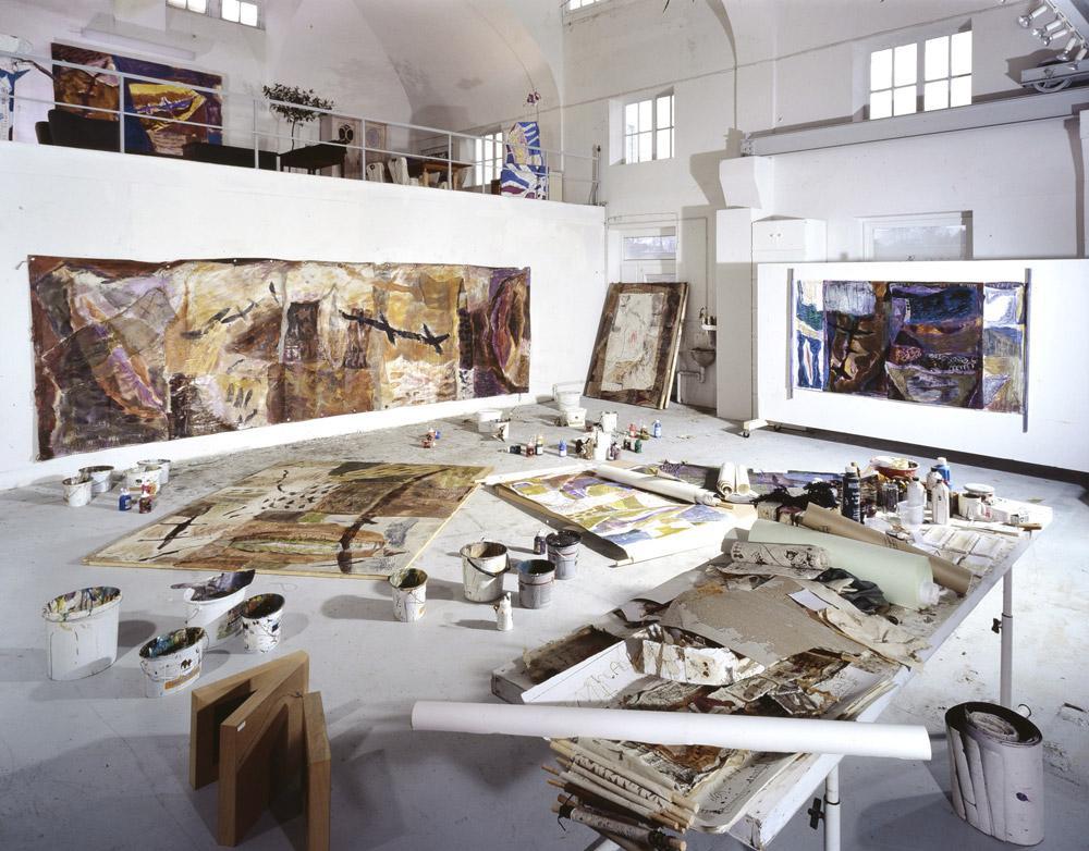 Large artist studio with natural light, busy with maker materials. 